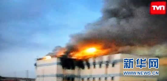 这张2010年12月8日获取的电视截图显示智利首都圣地亚哥圣米格尔监狱正在燃烧。 新华社/法新