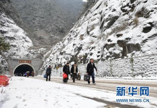 1月19日，返乡民工带着行李在319国道上徒步行走。当日是全国春运首日，渝东南地区受到严重的冰雪天气影响，部分客运车辆停运。新华社记者 陈诚 摄