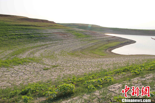 近日，受特大干旱影响，南水北调中线工程水源地丹江口水库水位一度跌破历史最低。图为丹江口水库库岸因干旱龟裂。中新社发 王东 摄